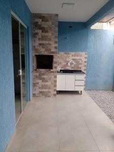 a room with a stone wall and a white cabinet at casa de praia em Matinhos in Matinhos