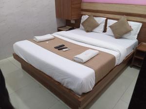 - un grand lit avec 2 chaussons et des serviettes dans l'établissement Hotel Shree Krishna, à Ahmedabad