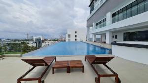 a balcony with two chairs and a swimming pool on a building at The Suites SGR Melaka in Melaka