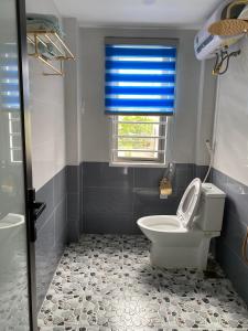 a bathroom with a toilet and a window at Xuân Hạ Thu Đông Motel in Ha Long