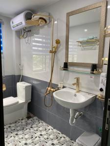 a bathroom with a sink and a toilet and a mirror at Xuân Hạ Thu Đông Motel in Ha Long