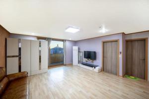 a living room with a couch and a television at Yongmaru Pension in Suncheon