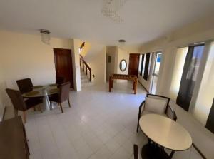 a dining room with two tables and chairs and windows at Hostal Judy Suites in Salinas