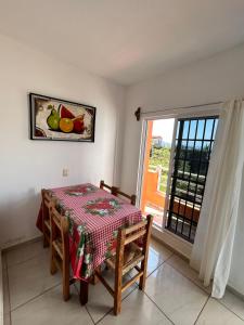 a dining room with a table and a window at Bungalows BuenaVista in Chacala
