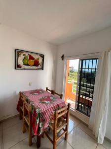 a dining room with a table and a window at Bungalows BuenaVista in Chacala