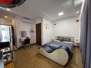 Schlafzimmer mit einem Bett, einem Schreibtisch und einem TV in der Unterkunft Ngoc An Hotel in Tây Ninh