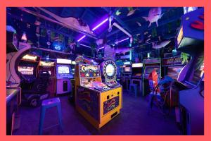 a room filled with lots of video game machines at Underwater Voyage: Heated Pool, Arcade, more! in Garden Grove