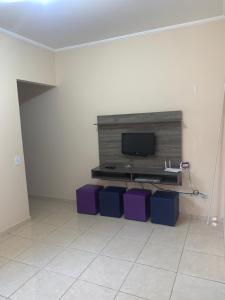 a living room with a flat screen tv on a wall at Casa em Peruíbe in Peruíbe +6 photos