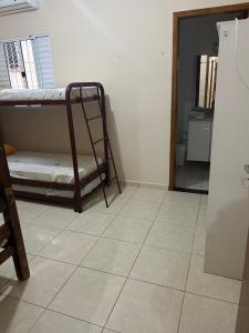 a room with two bunk beds and a tiled floor at Casa em Peruíbe in Peruíbe