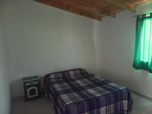 a small bedroom with a bed and a window at Alberto Beach in Las Grutas