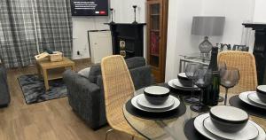 ein Wohnzimmer mit einem Tisch und Stühlen mit Hüten darauf in der Unterkunft Contractors Grove 2 Bed House Town Centre Location in Wellingborough