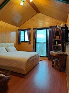 1 dormitorio con 1 cama en una habitación con ventanas en Mo Huai Su-桃園市民宿085號 en Hualing