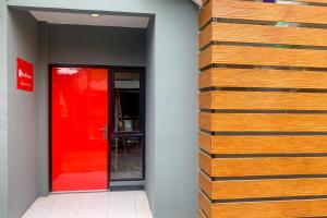 a wooden wall next to a red door at RedDoorz @ Balaraja Centre Plaza in Tangerang