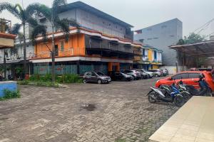 a parking lot with cars parked in front of a building at RedDoorz @ Balaraja Centre Plaza in Tangerang
