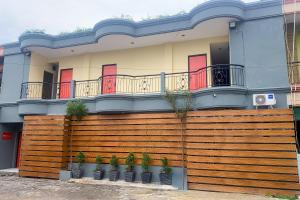 a house with a wooden fence and potted plants at RedDoorz @ Balaraja Centre Plaza in Tangerang