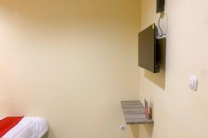 a bedroom with a bed and a tv on the wall at RedDoorz @ Balaraja Centre Plaza in Tangerang