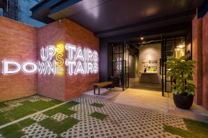 a building with a sign that says up stairs down trains at Upstairs Downstairs CoLiving Bukit Bintang in Kuala Lumpur