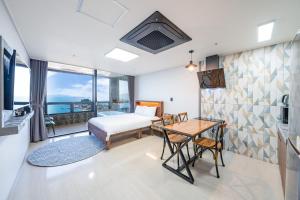 ein Schlafzimmer mit einem Bett und einem Tisch mit einem Tisch in der Unterkunft Le Paradis Ocen view Spa Pension in Yeosu