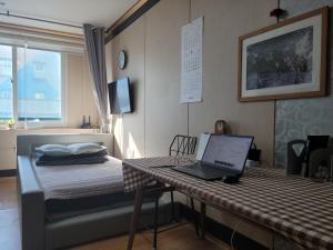 a bedroom with a bed with a laptop on a desk at Canberra Town 439-3 in Changwon