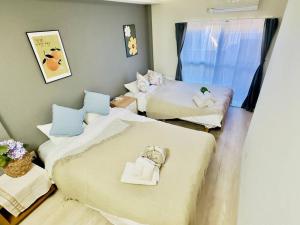 a room with two beds and a window at 100m from nearest bus stop/8 mins to Ikebukuro sta in Tokyo