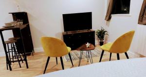 a living room with two chairs and a television at Market Haven Kingsize Studios Town Centre with Netflix, Business & Leisure travellers, multiple units available in Northampton