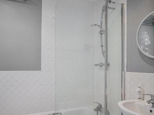 a white bathroom with a shower and a sink at The Gainsborough Mews in Gainsborough