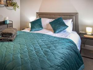 a bedroom with a large bed with blue sheets and pillows at The Gainsborough Mews in Gainsborough