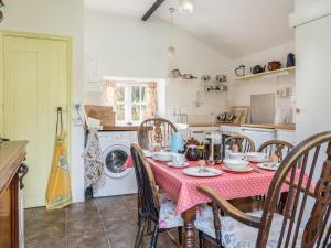 Gore Cottage في Powerstock: مطبخ مع طاولة مع قماش الطاولة الحمراء
