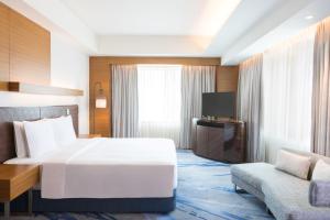 una camera d'albergo con un grande letto e un divano di Radisson Blu Cebu a Cebu City