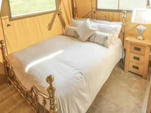 1 dormitorio con 1 cama con sábanas y almohadas blancas en Lime Kiln Lodge - Ukc6262, en Castle Cary