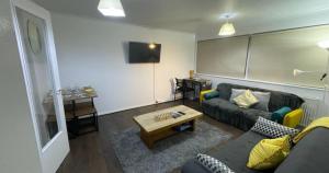 a living room with a couch and a table at Cosy Central MK Apartment Sky Tv Netflix and Free Parking in Milton Keynes