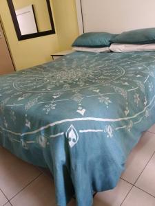 a bed with a blue blanket on top of it at AGNES GUEST HOUSE in Germiston