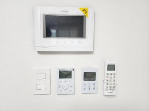 a microwave with four electronic devices on a wall at Sokcho Summitbay 1701 "Ocean View" in Sokcho