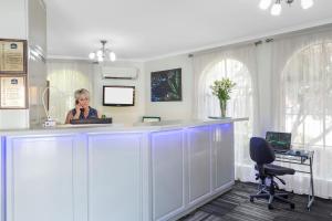 a woman sitting at a counter in a room at Cathedral Motor Inn in Bendigo