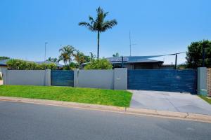 a fence in front of a house with a yard at Tranquil Scape-Villa with Pool by Gold Coast Premium in Gold Coast