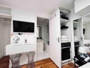 a white bathroom with a tv on the wall at Iconic location only 500 meters to The Louvre in Paris