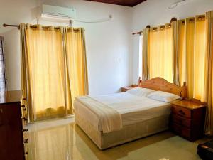 a bedroom with a bed and yellow curtains at No 10 @ Carlwil place in Colombo