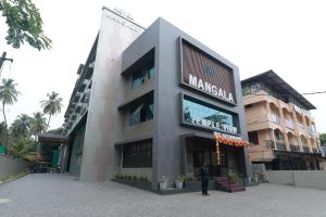 a person standing in front of a building at Hotel Mangala Temple View in Guruvāyūr