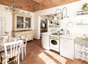 a kitchen with white appliances and a table with chairs at Spello House Patio in Spello