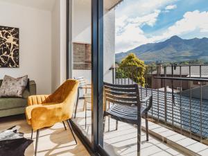 a room with a balcony with a couch and chairs at Le Jardin in George