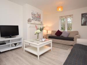 a living room with a couch and a tv at 4 Bed in Corfe Castle 62985 in Worth Matravers