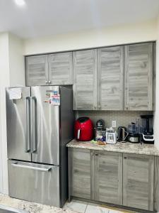 a kitchen with a stainless steel refrigerator and cabinets at Niagara Falls Double Bedroom in Thorold