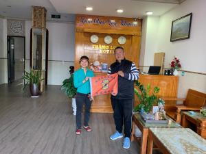 un hombre y una mujer sosteniendo una cometa en una habitación en Thăng Long Hotel, en Dong Hoi