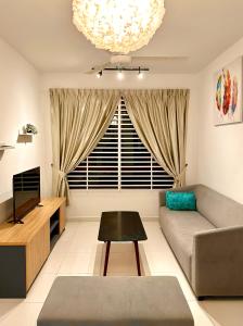 a living room with a couch and a television at Nureenas Residence Condominium in Ayer Keroh