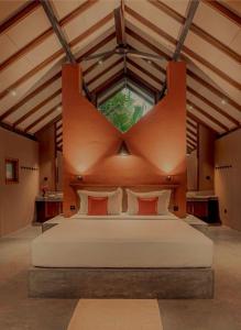 a bedroom with a large bed with a large window at Nisala Villas in Hikkaduwa