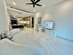 ein Wohnzimmer mit weißen Möbeln und einem Flachbild-TV in der Unterkunft Eaton Residence in Kuala Lumpur