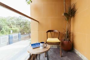 a table with a laptop and a chair on a balcony at Draper Startup House for Entrepreneurs Hyderabad in Hyderabad