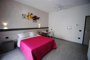 Novo Motel في تورتوريتو ليدو: غرفة نوم بسرير وردي وطاولة