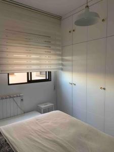 a white bedroom with a bed and a window at Apto residencial piscina centro-Parking in Jaén +11 photos