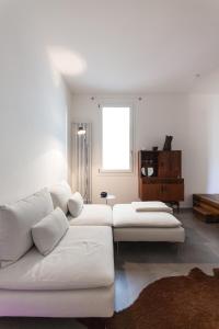 a living room with a white couch and a window at @HOME - Mini In Centro Storico in Padova